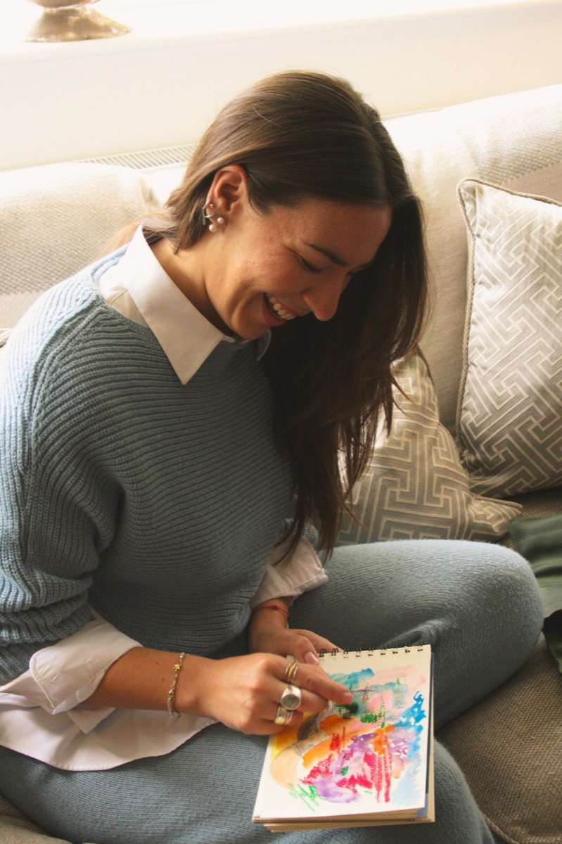 Lou Lou smiling as she paints in a sketchbook