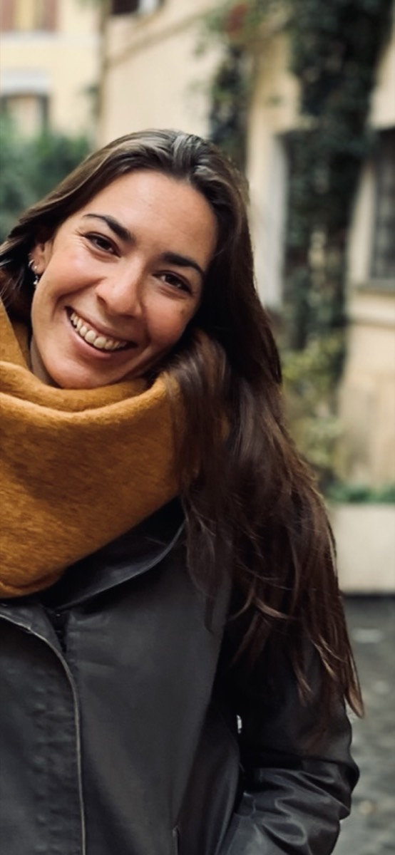 Lou Lou smiling outdoors in a mustard scarf