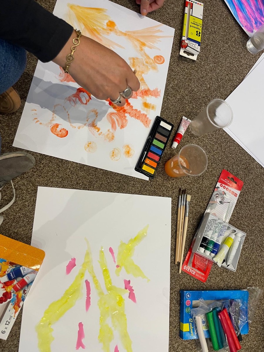 Overhead view of hands painting with watercolours during a session